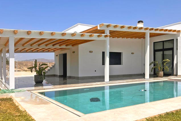 Pérgola de tronco y madera blanca para terraza de acceso a vivienda en Almerimar 